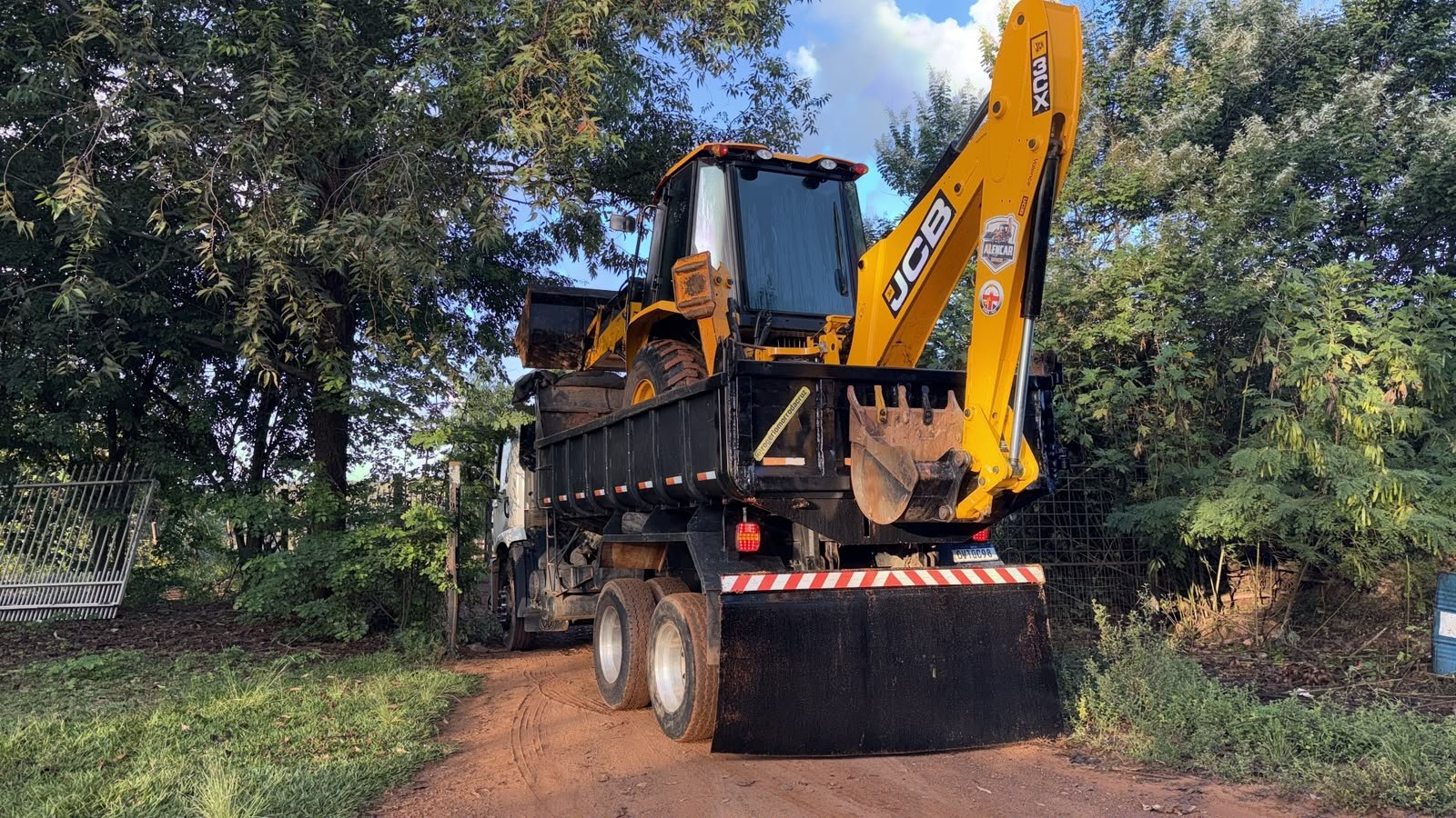 Retroescavadeira JCB 3CX carregada no caminhão.