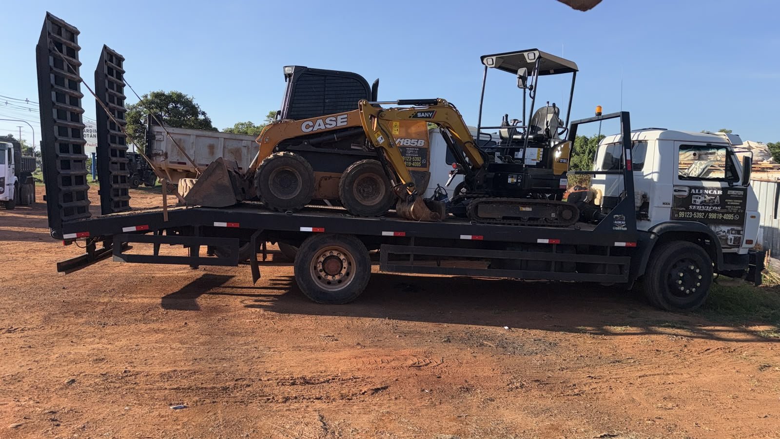 Caminhão prancha da Alencar Serviços carregado com skid steer CASE e mini escavadeira SANY.