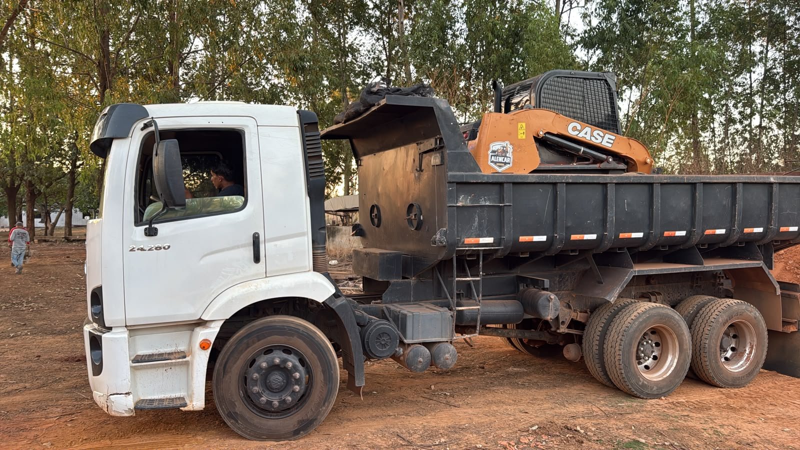 Skid steer CASE carregado na caçamba.